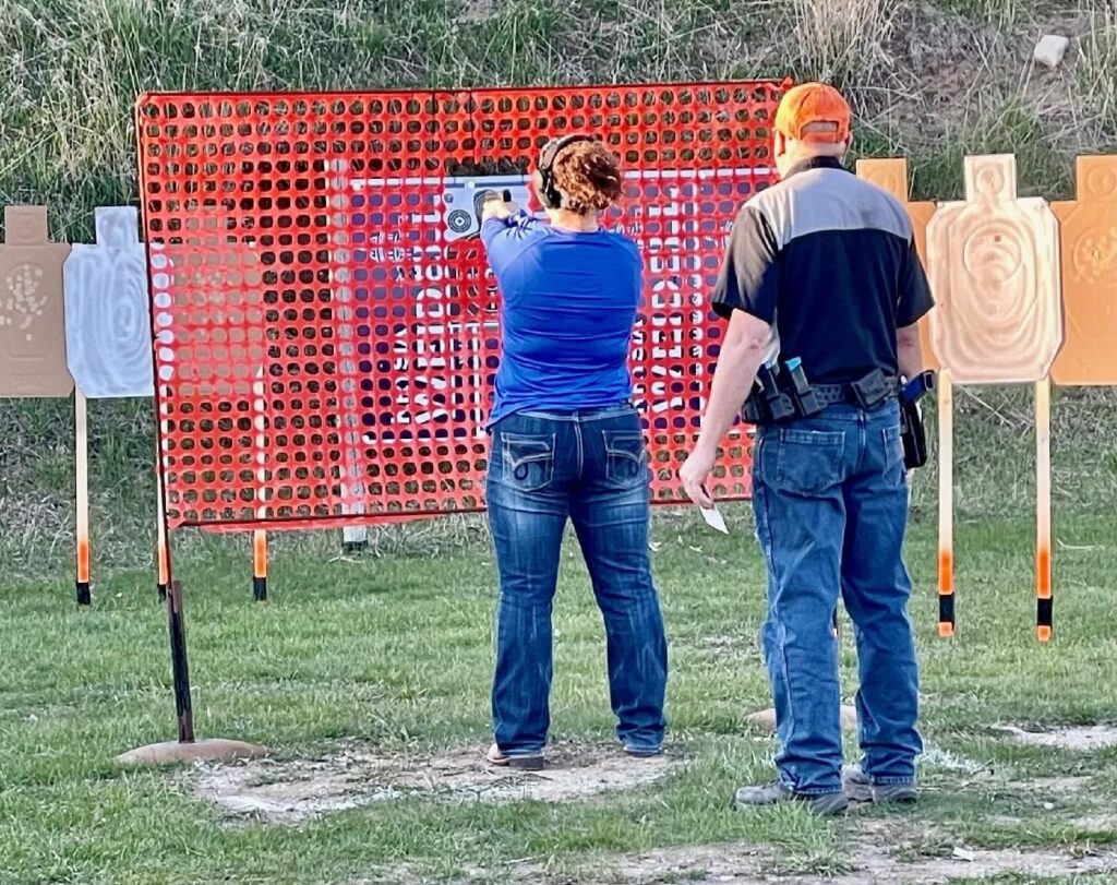 a women with instructor aiming to shoot target