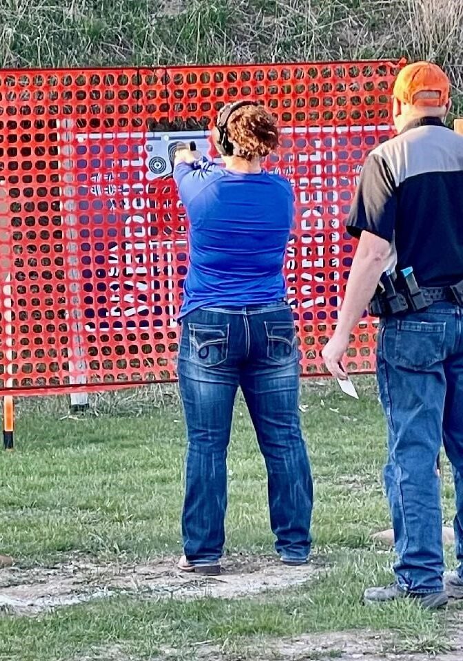 a women with instructor aiming to shoot target