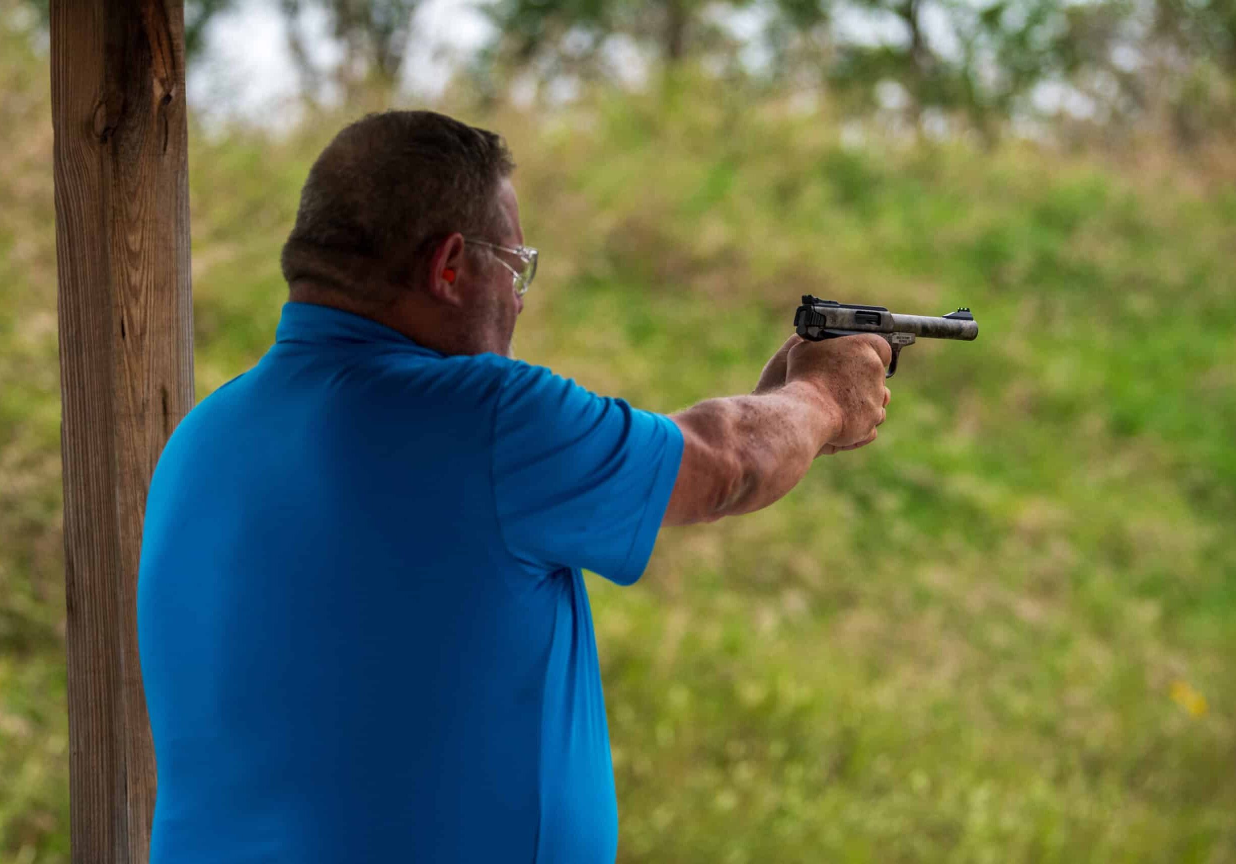 man aiming pistol at target