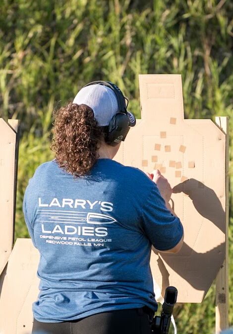 woman checking target at shooting range